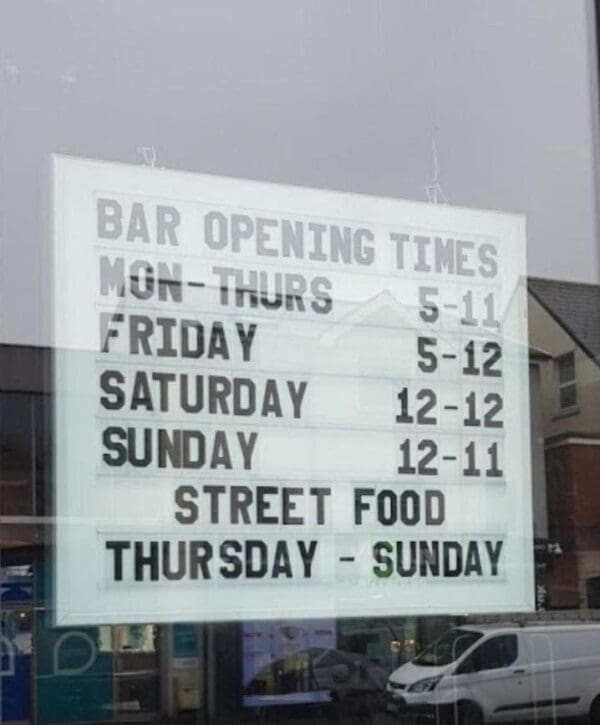 opening time sign using changeable letters in window of bar